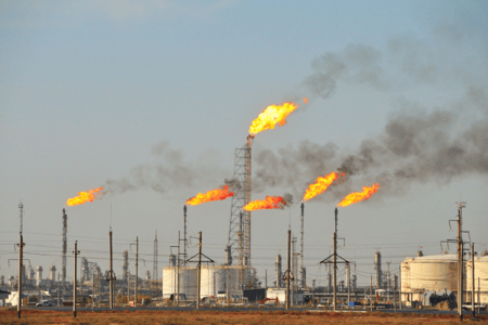 An oil refinery burning flares into the sky